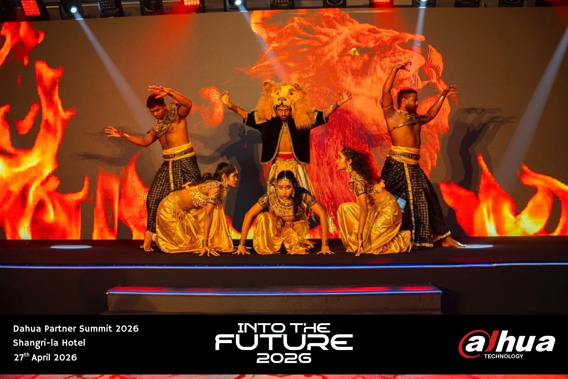 Dancers in gold costumes performing a lion-themed act on stage in front of a fiery LED backdrop at the Shangri-La Hotel